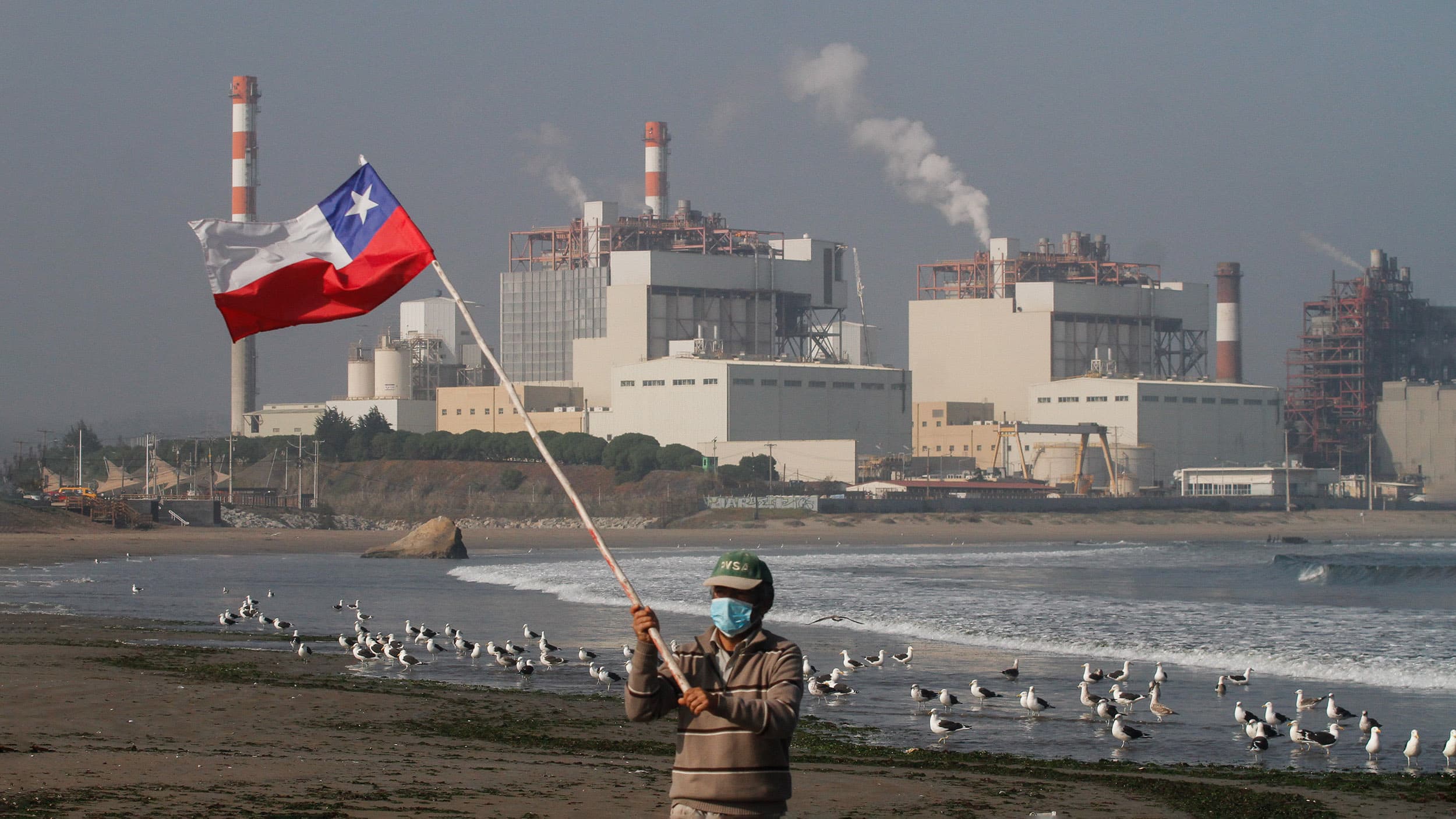 Una persona se manifiesta en la Bahía de Quineros-Puchuncaví para exigir medidas contra la industria después de un caso de contaminación.